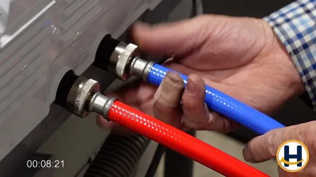 attaching the hot and cold water hoses to the valves